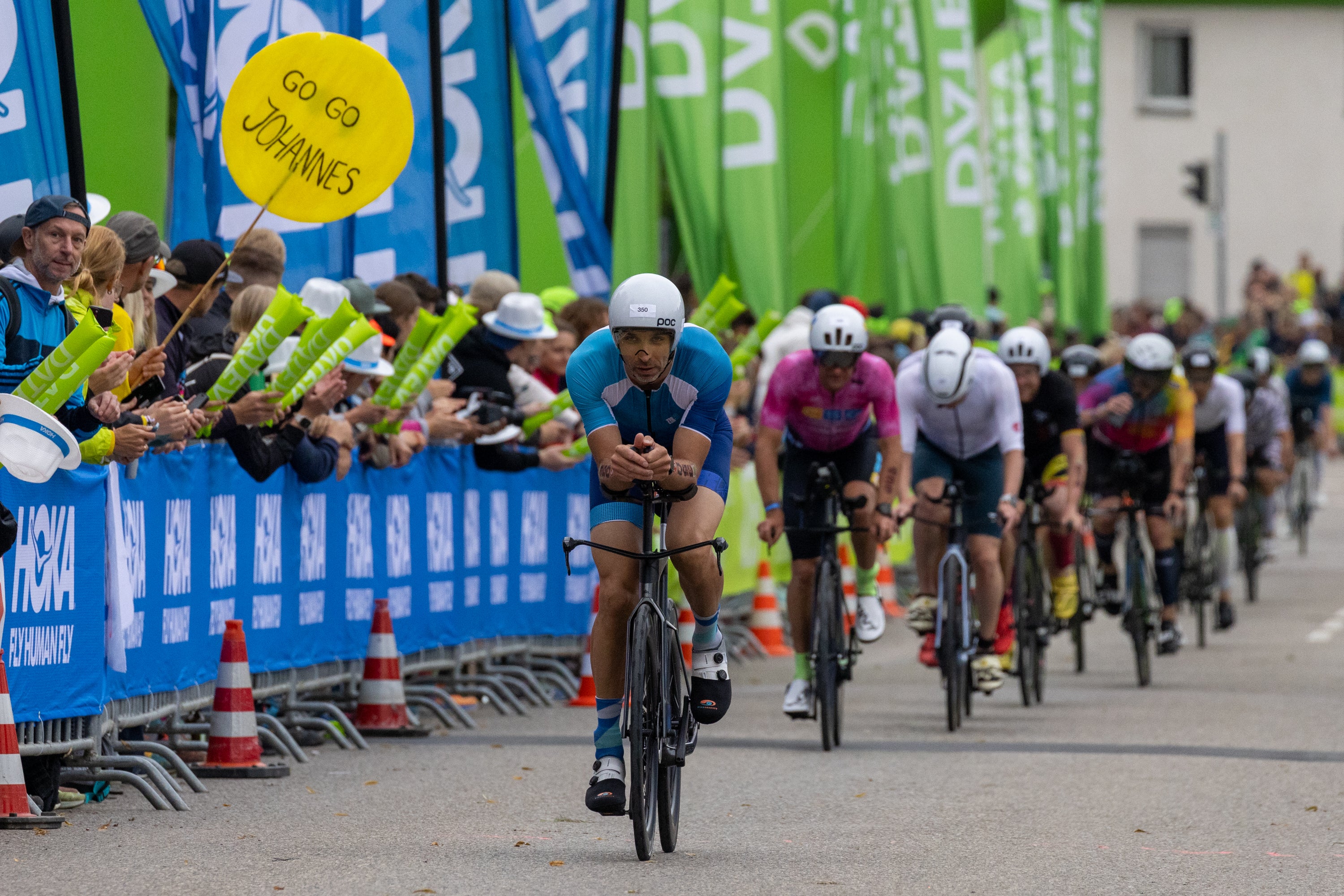 Triathleten auf dem Rad von vorn fahren in einer langgezogenen Reihe hintereinander