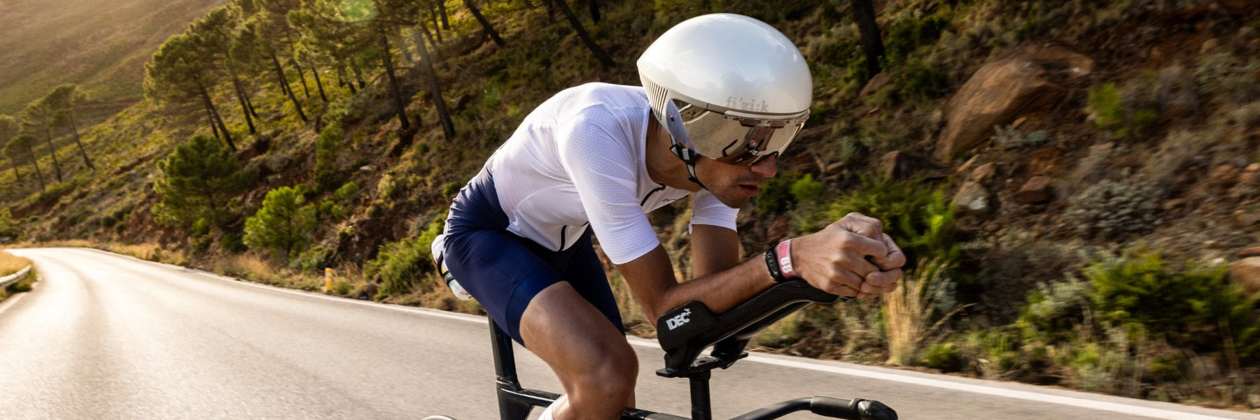 Ein Triathlet auf seinem Rad in Nahaufnahme von schräg vorn. Er liegt auf seinen Auflieger in aerodynamischer Position.