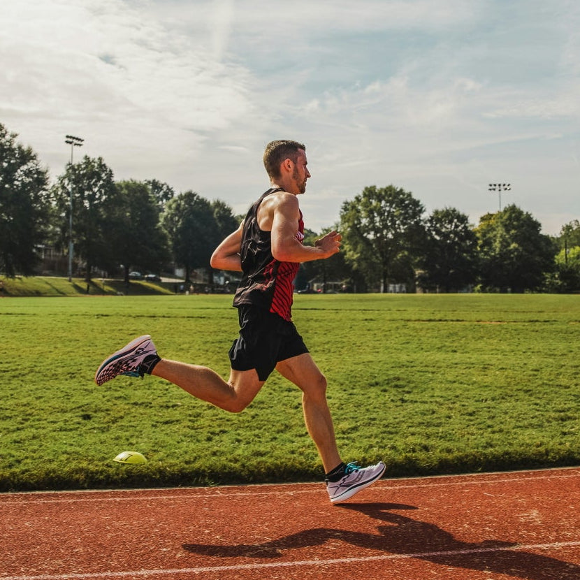 Ein Läufer beim Intervalltraining auf einer Tartanahn, Ansicht von der Seite